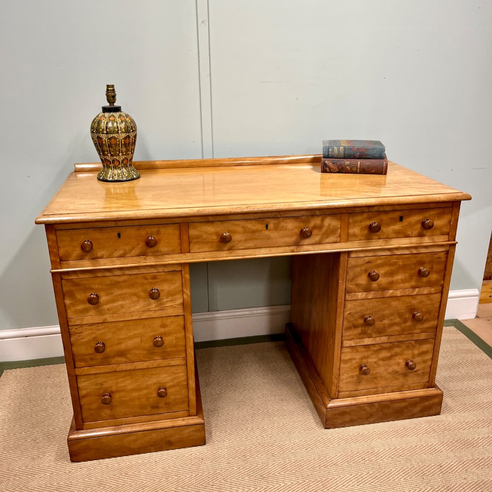 A 19th-century satin birch twin-pedestal desk featuring nine drawers with turned wooden knobs and a low gallery back. View III