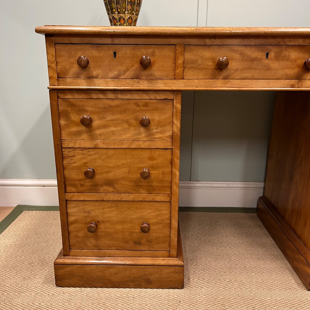 A 19th-century satin birch twin-pedestal desk featuring nine drawers with turned wooden knobs and a low gallery back. View IV