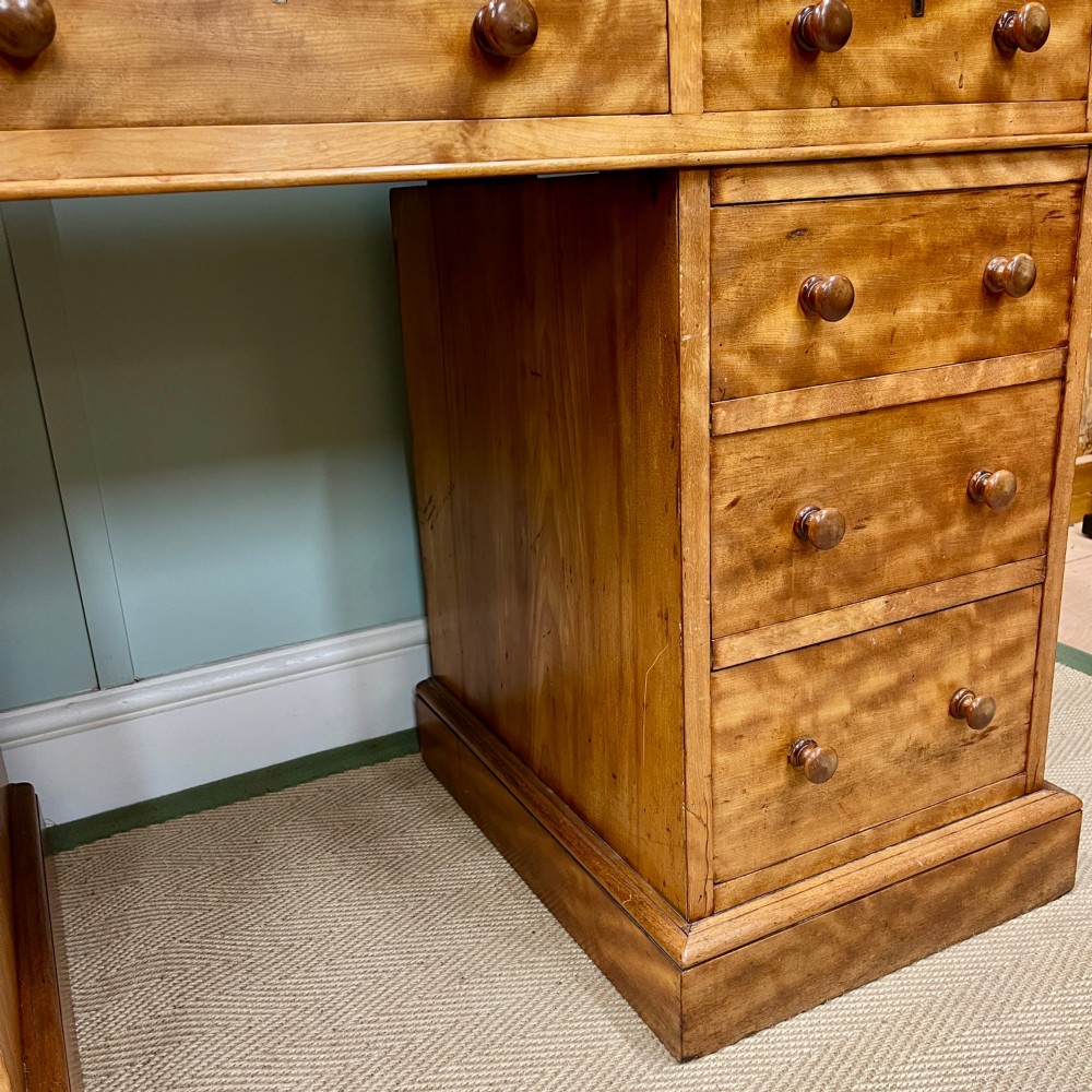 A 19th-century satin birch twin-pedestal desk featuring nine drawers with turned wooden knobs and a low gallery back. View V