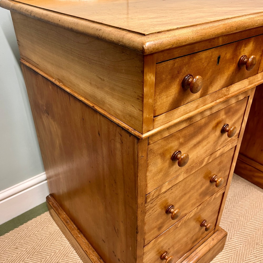 A 19th-century satin birch twin-pedestal desk featuring nine drawers with turned wooden knobs and a low gallery back. View IX
