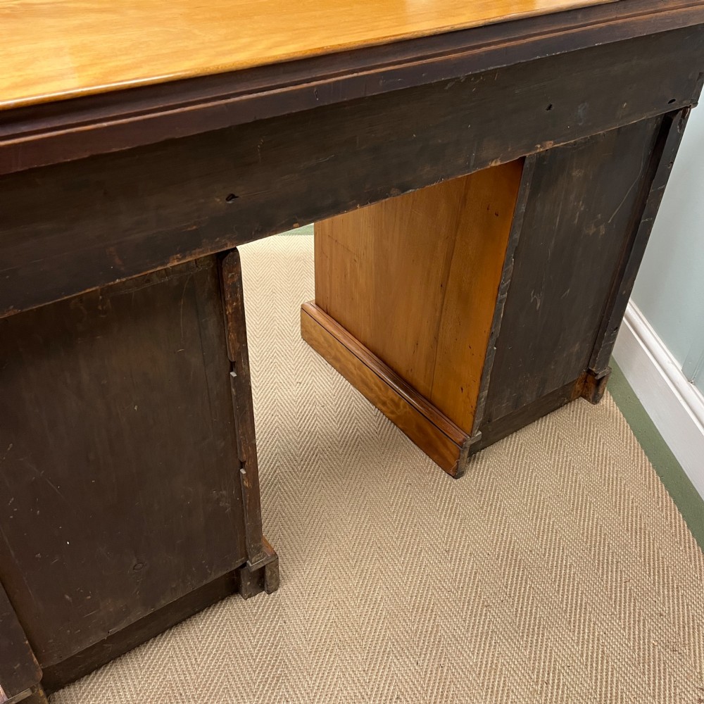 A 19th-century satin birch twin-pedestal desk featuring nine drawers with turned wooden knobs and a low gallery back. View X