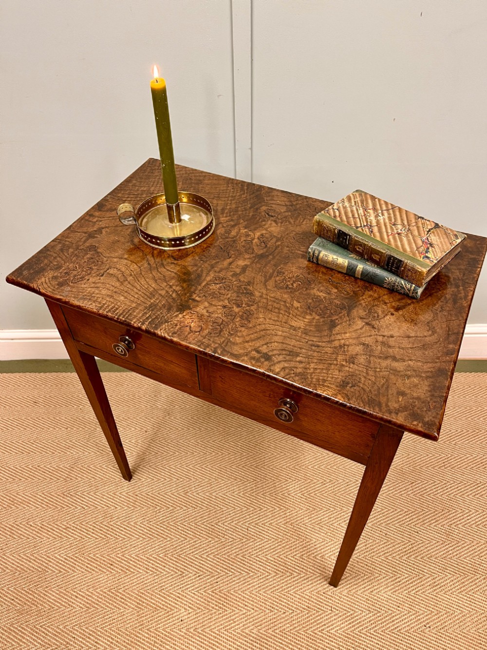 A 19th-century burr ash side table featuring two front drawers with round brass knobs and slender tapered square legs. View II