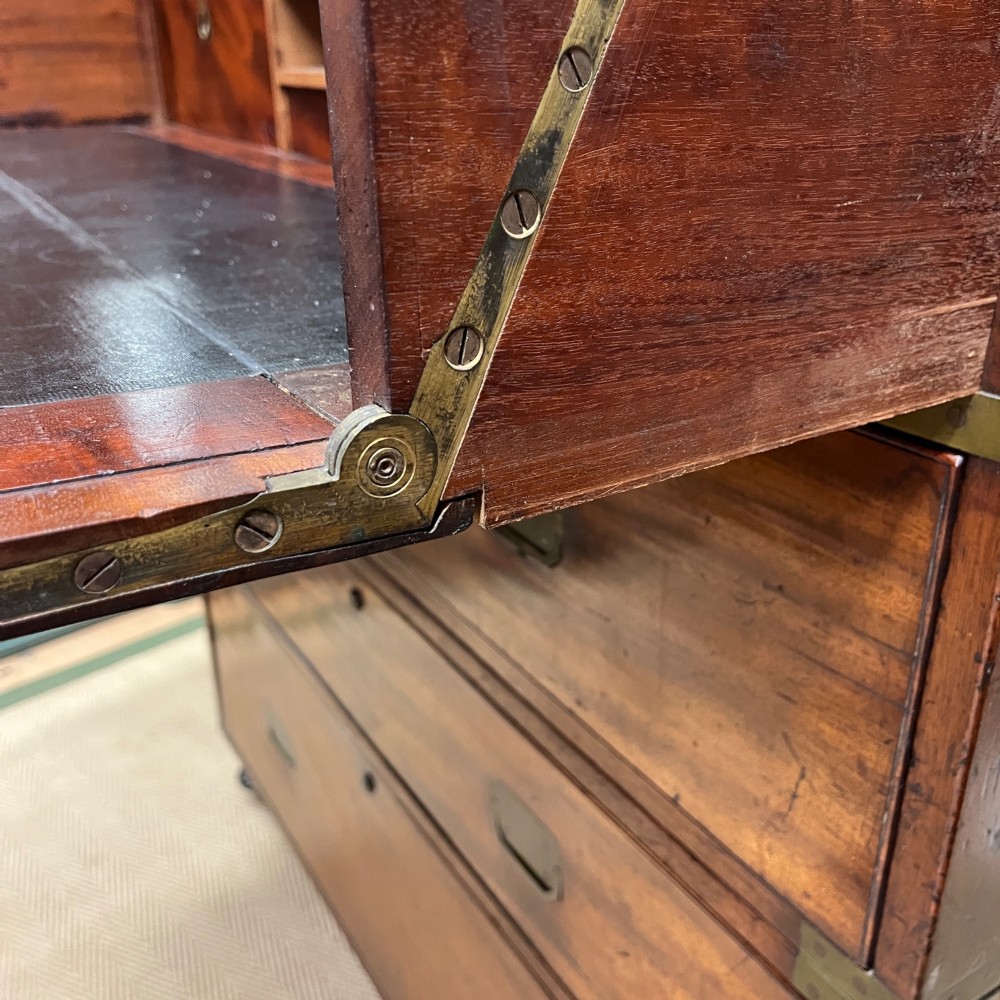 A 19th-century mahogany military campaign secretaire chest featuring four drawers with recessed brass handles and brass corner straps, resting on turned feet. View IX
