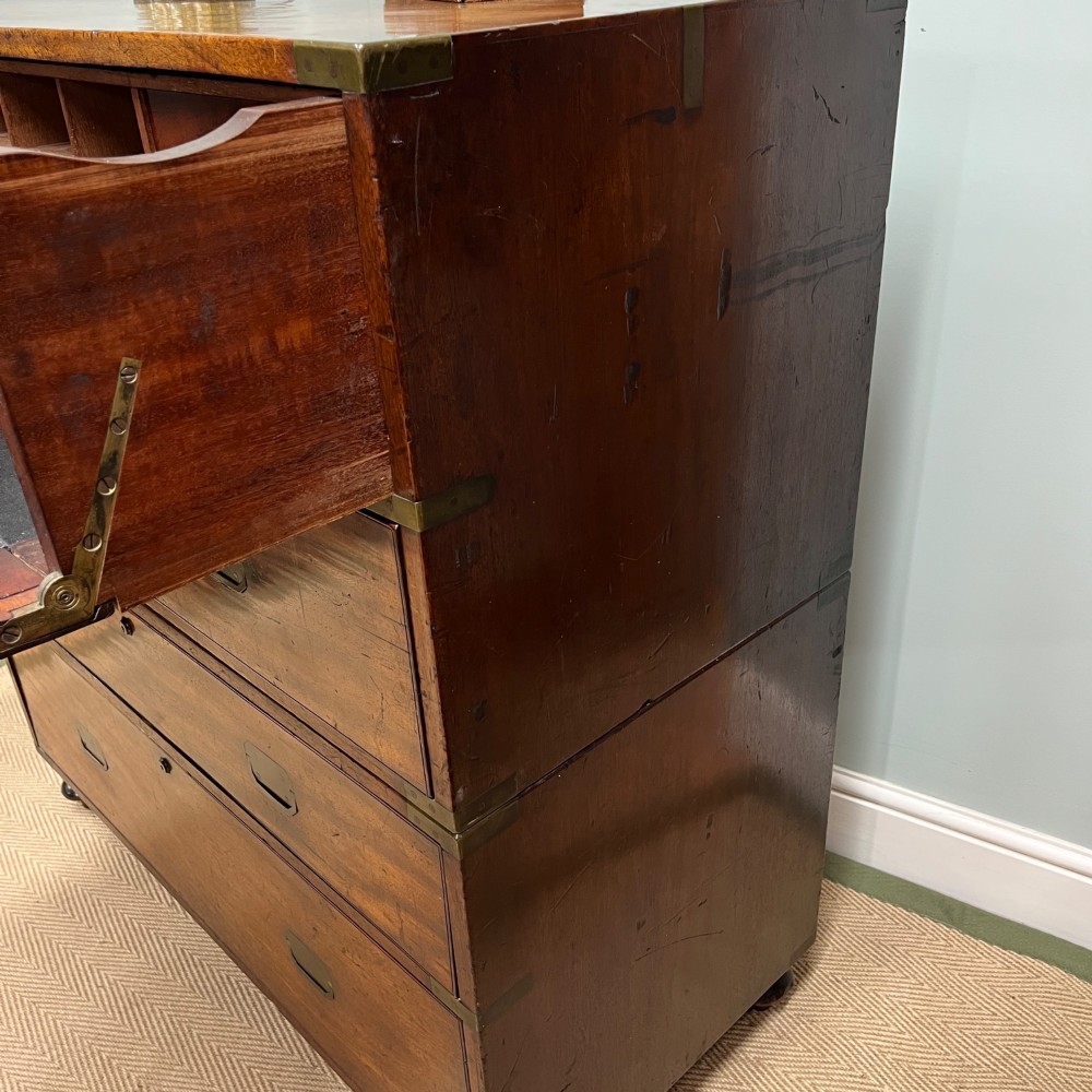 A 19th-century mahogany military campaign secretaire chest featuring four drawers with recessed brass handles and brass corner straps, resting on turned feet. View X