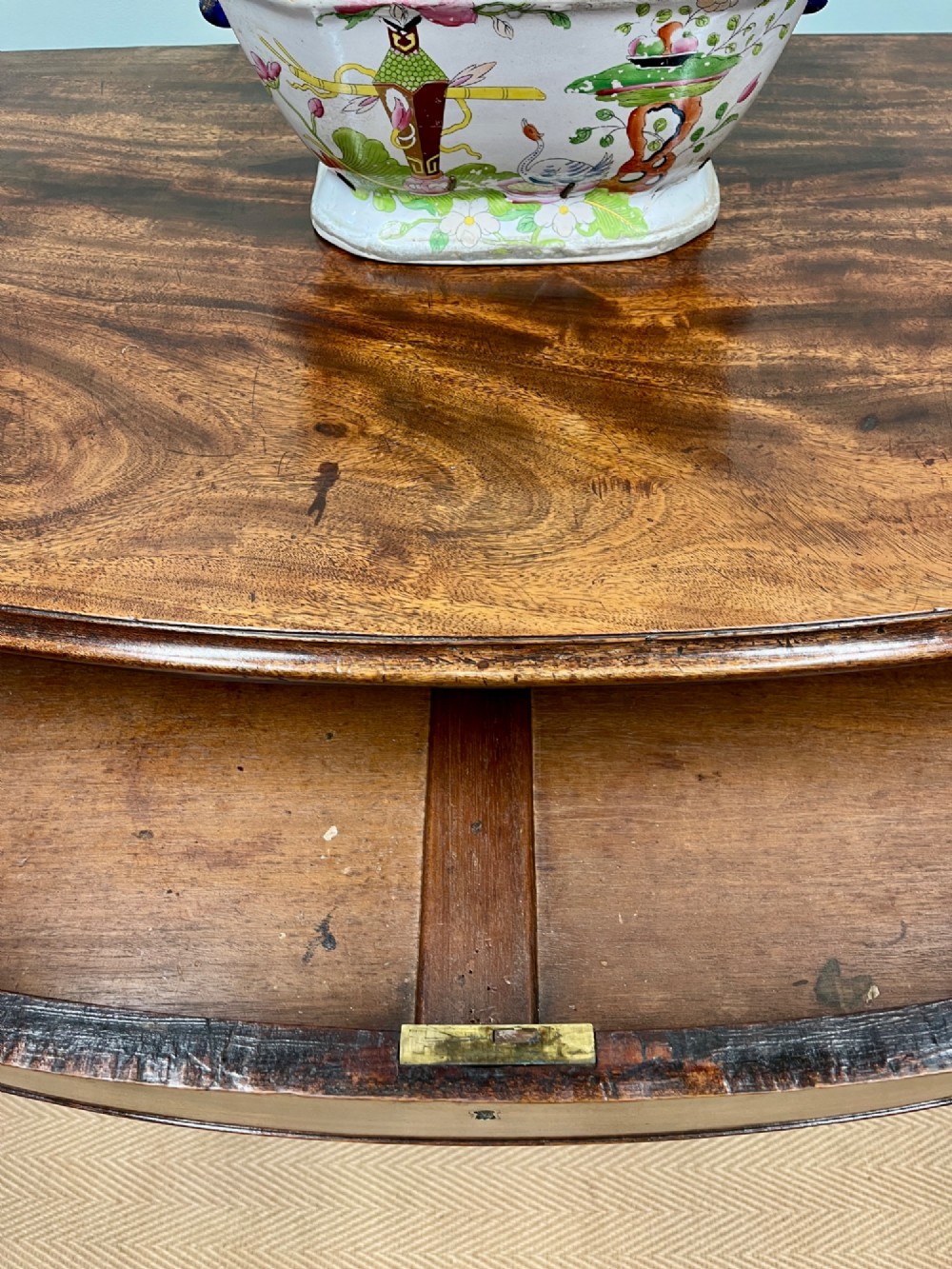 An antique Regency bow-fronted mahogany chest of drawers with four graduated drawers, brass ring handles, and splayed bracket feet. View V