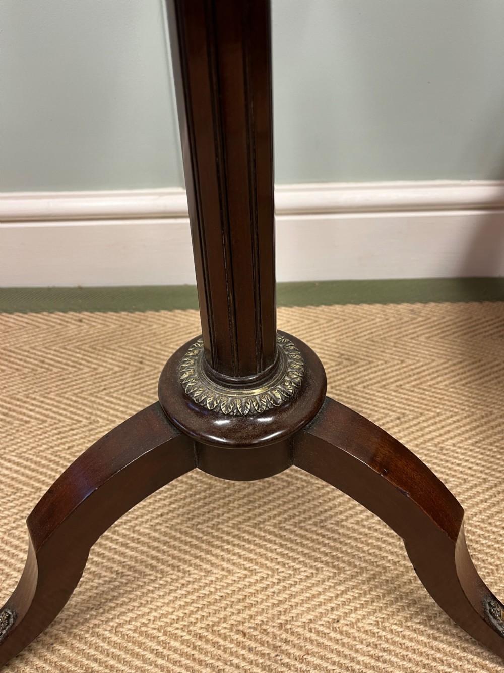 A two-tier dark mahogany dumb waiter featuring pierced brass galleries, a fluted central stem, and a tripod base with brass feet. View III