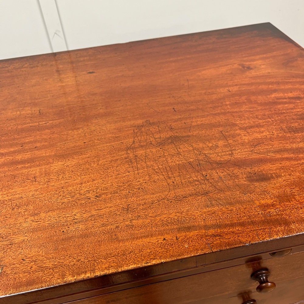A tall Victorian mahogany Wellington chest featuring eight graduated drawers with turned wooden knobs, carved corbels at the top, and a side hinged locking flap on a plinth base. View IX