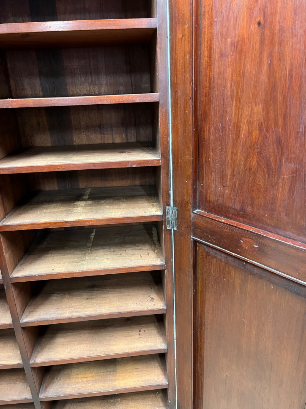 A tall, slim 19th-century mahogany cupboard featuring twin panelled doors and a solid plinth base. View V