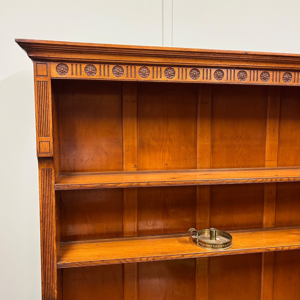 A 19th-century oak dresser featuring a three-tiered open shelf rack above two drawers with brass swan-neck handles and an open pot board base on turned legs. View II