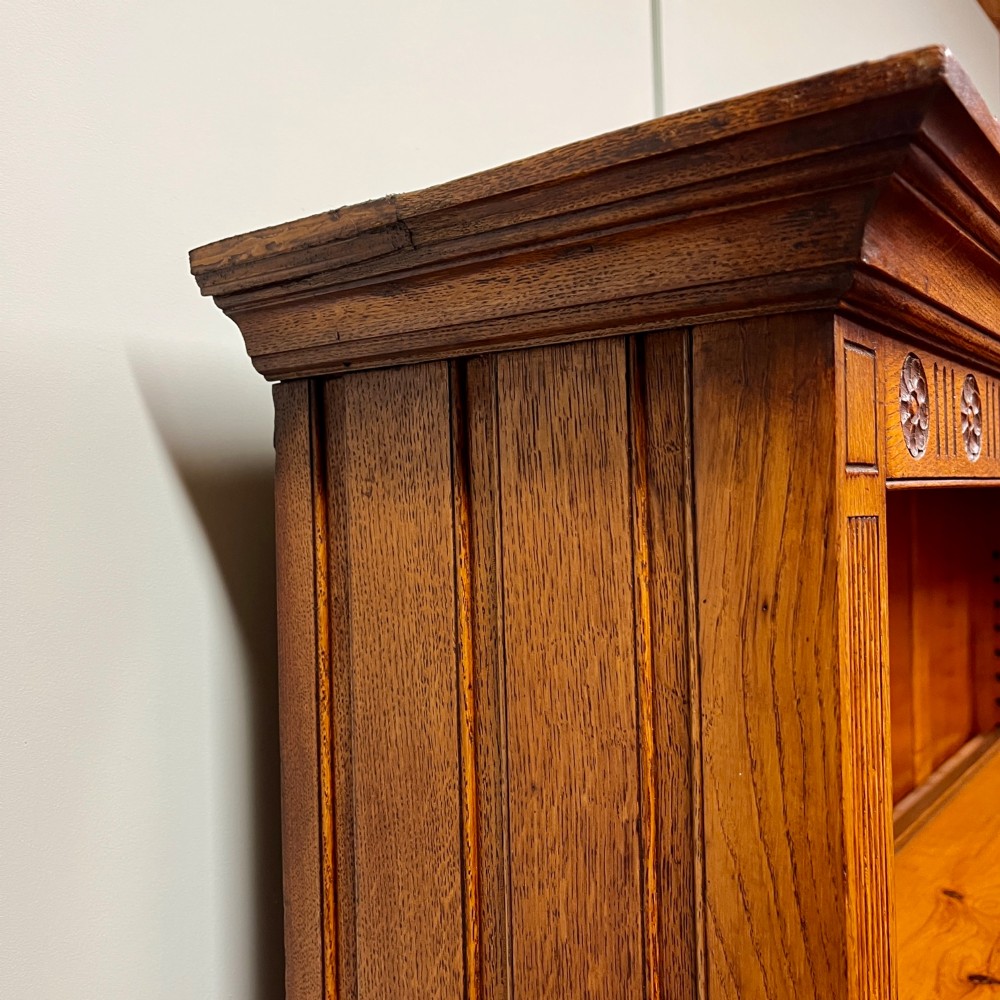 A 19th-century oak dresser featuring a three-tiered open shelf rack above two drawers with brass swan-neck handles and an open pot board base on turned legs. View VI