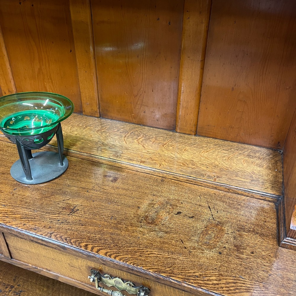 A 19th-century oak dresser featuring a three-tiered open shelf rack above two drawers with brass swan-neck handles and an open pot board base on turned legs. View VIII