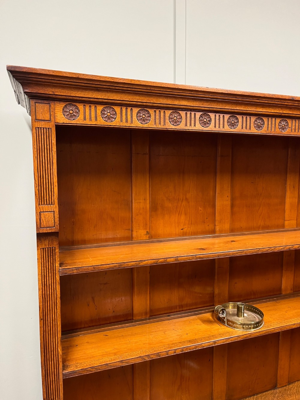 A 19th-century oak dresser featuring a three-tiered open shelf rack above two drawers with brass swan-neck handles and an open pot board base on turned legs. View IX