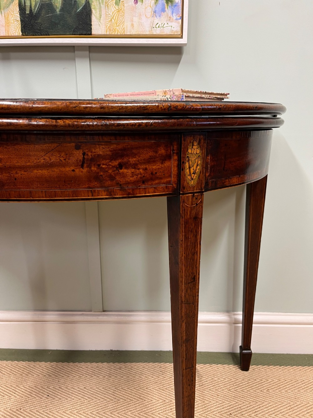A Georgian mahogany demilune tea table featuring wood stringing and four tapered square legs. View III