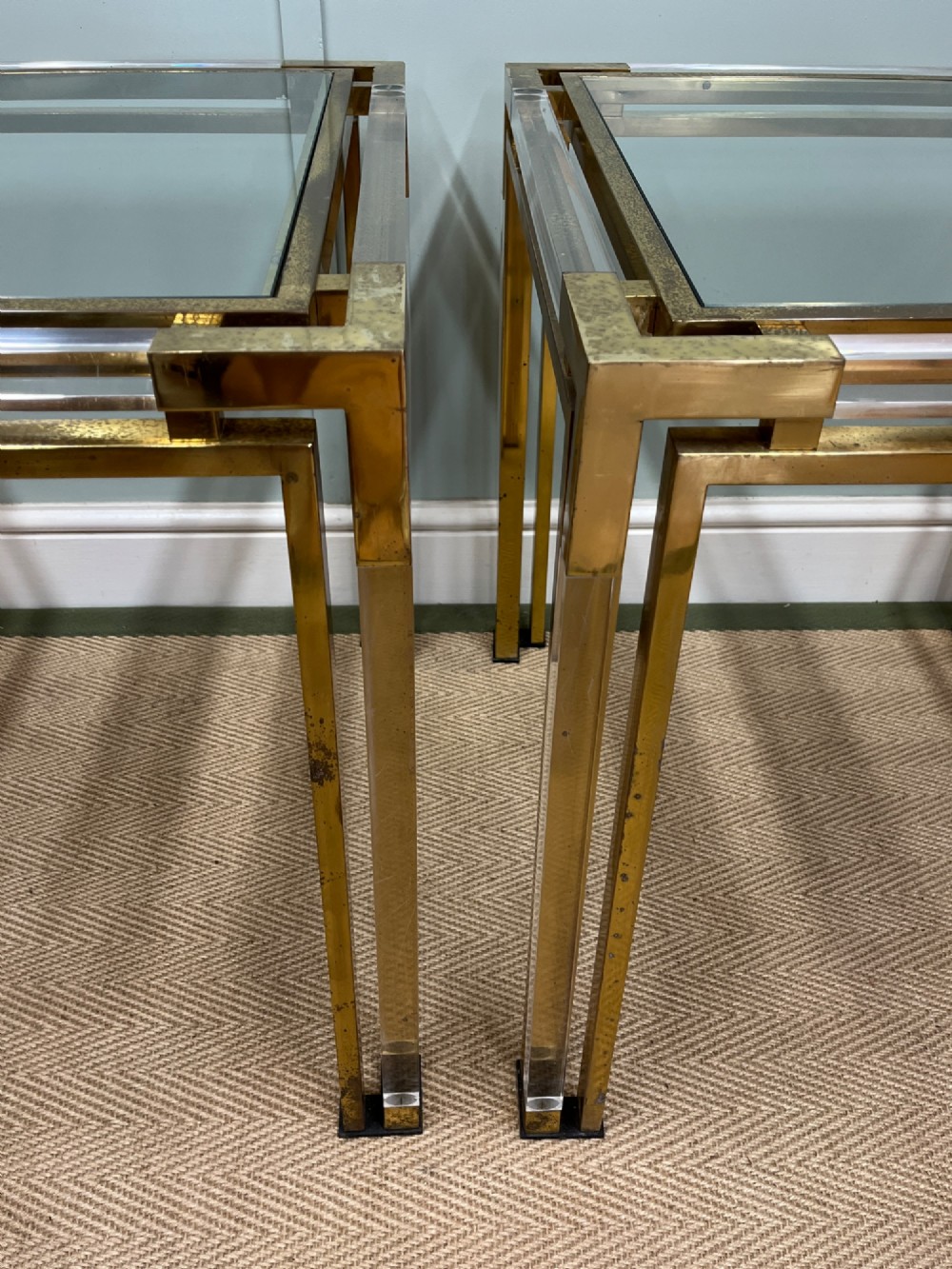 A pair of square side tables featuring brass frames, clear lucite corner inserts, and glass tops. View VII