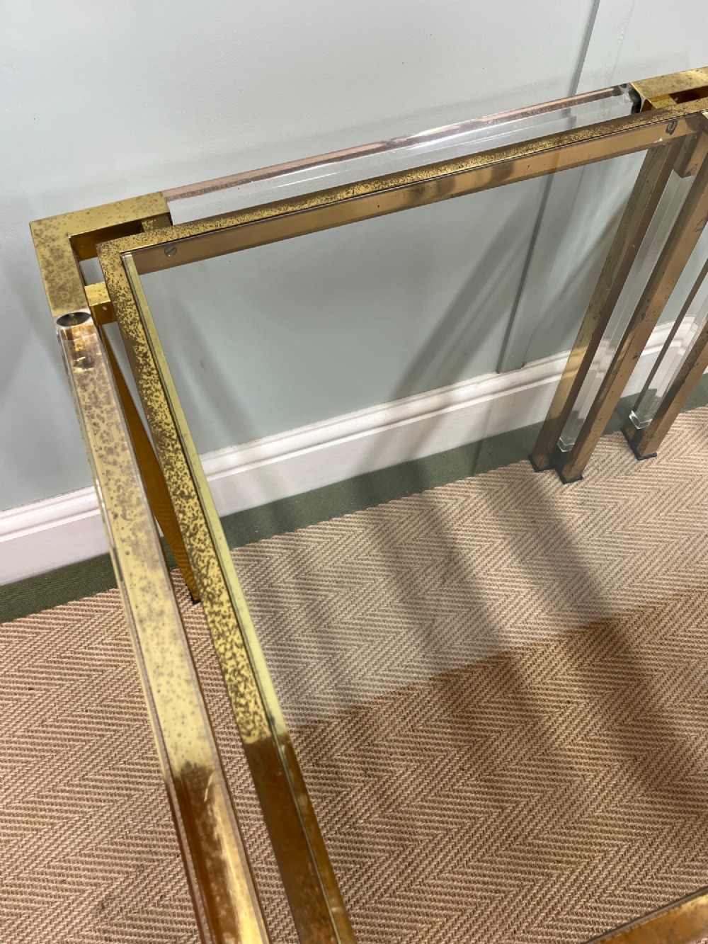 A pair of square side tables featuring brass frames, clear lucite corner inserts, and glass tops. View IX