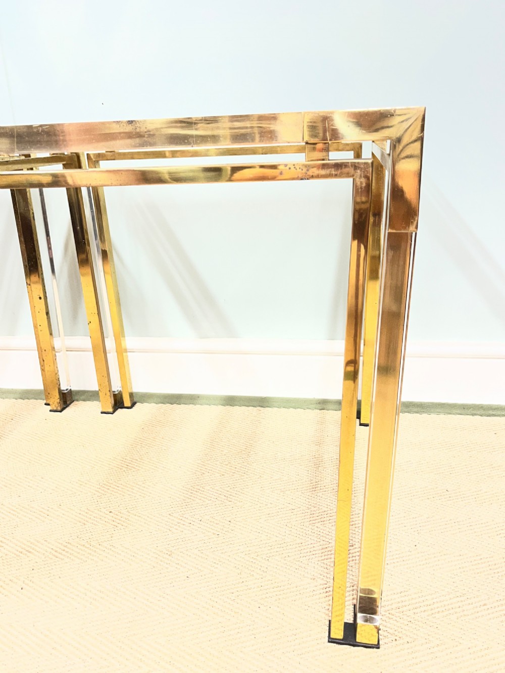 A pair of square side tables featuring brass frames, clear lucite corner inserts, and glass tops. View X
