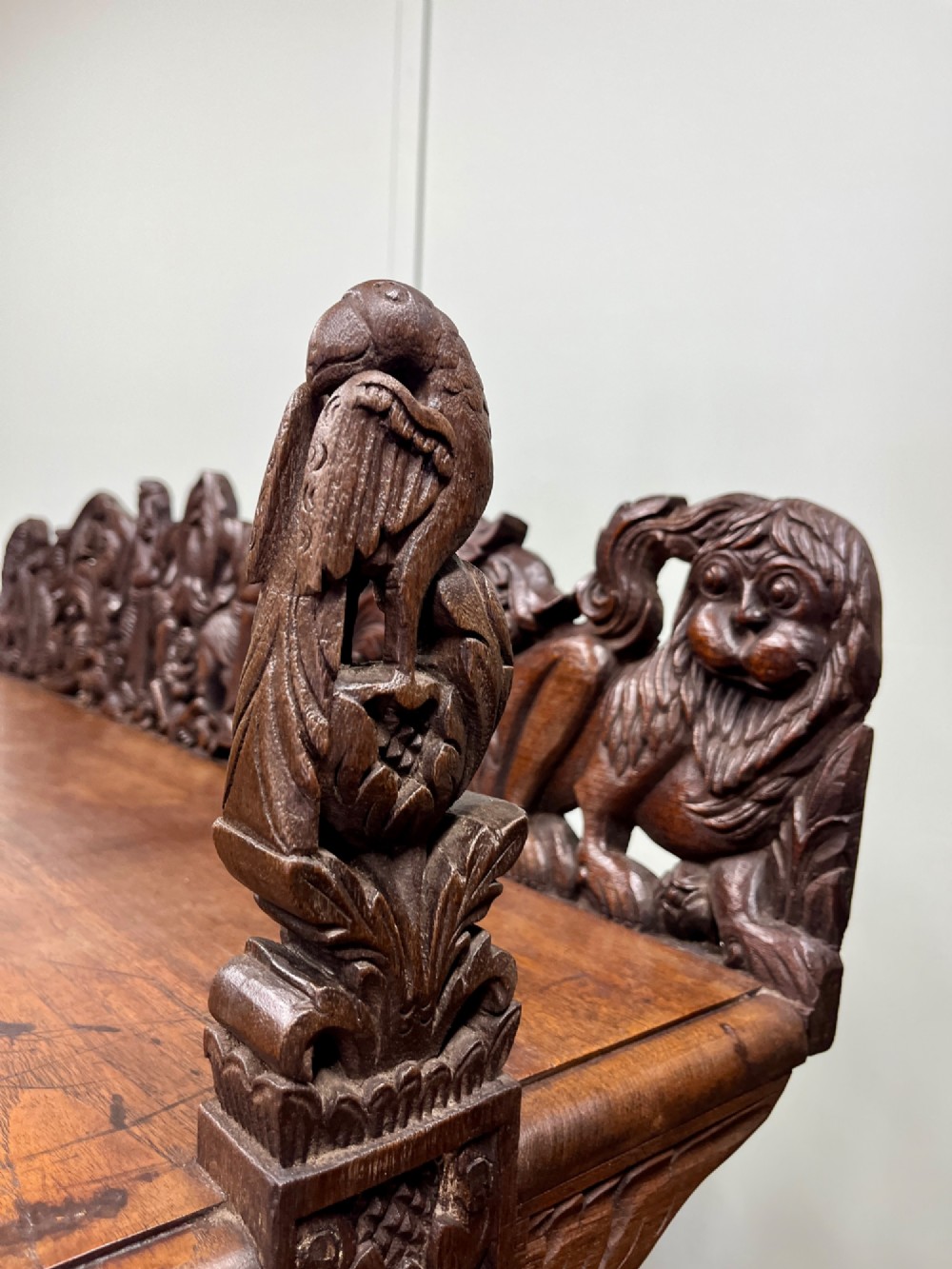A 19th-century carved dark teak three-tier buffet featuring relief-carved backboard galleries with figurative motifs, supported on carved uprights and trestle feet. View III