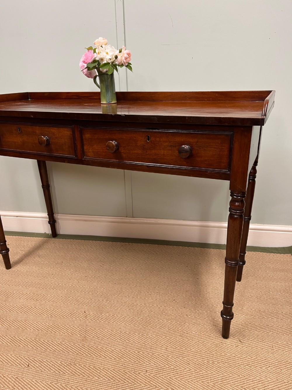 A 19th-century mahogany hall table with two frieze drawers, turned legs, and a raised gallery edge along the top. View IV