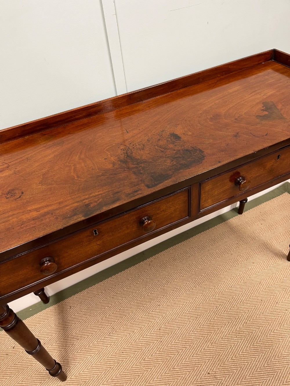 A 19th-century mahogany hall table with two frieze drawers, turned legs, and a raised gallery edge along the top. View VI