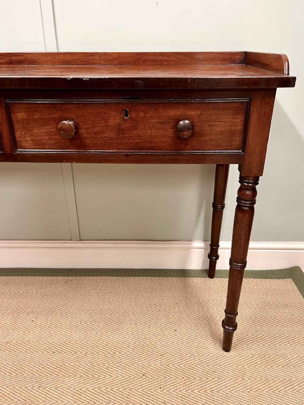 A 19th-century mahogany hall table with two frieze drawers, turned legs, and a raised gallery edge along the top. View VII