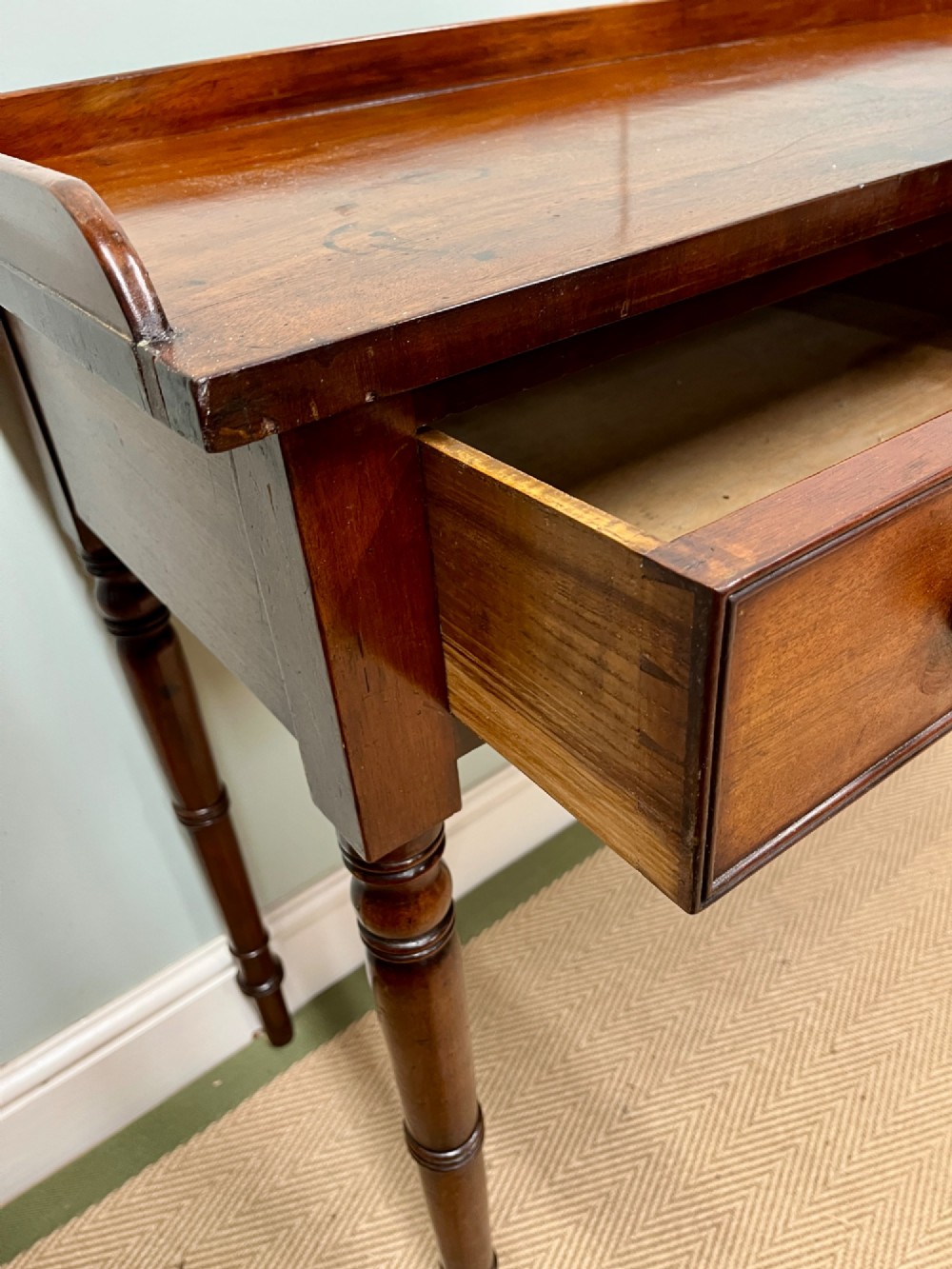 A 19th-century mahogany hall table with two frieze drawers, turned legs, and a raised gallery edge along the top. View VIII