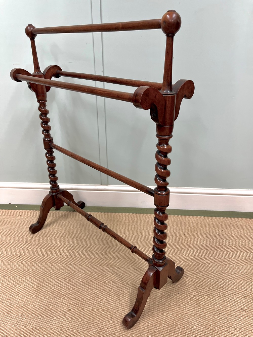 A 19th-century mahogany freestanding towel rail featuring barley twist uprights, turned rails, and carved trestle feet.