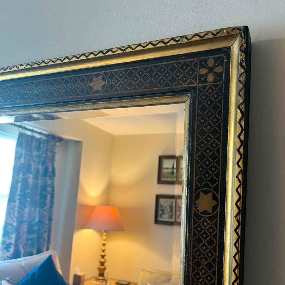 A large nineteenth-century rectangular wall mirror featuring a dark painted frame embellished with geometric motifs and a gilded outer border. View V