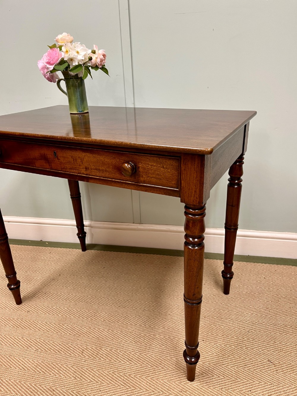 A 19th-century mahogany writing side table featuring a single frieze drawer with two wooden knobs and slender turned legs. View II