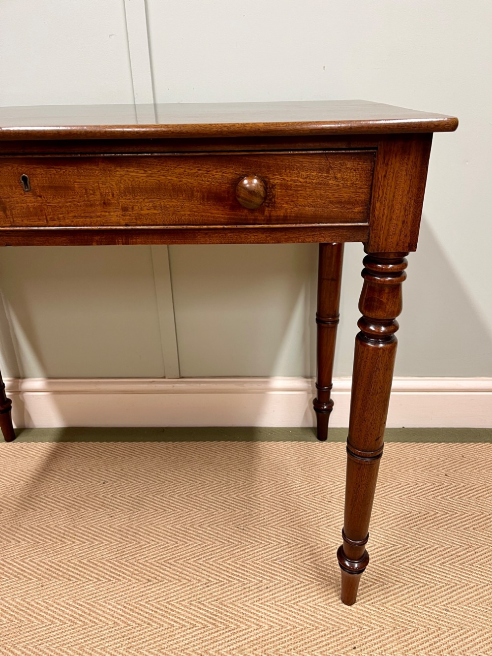 A 19th-century mahogany writing side table featuring a single frieze drawer with two wooden knobs and slender turned legs. View IV
