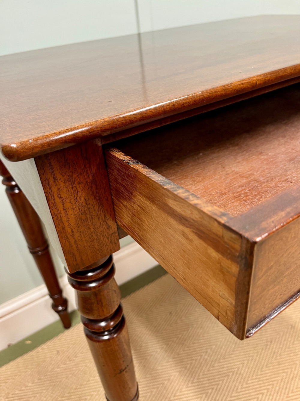 A 19th-century mahogany writing side table featuring a single frieze drawer with two wooden knobs and slender turned legs. View VI