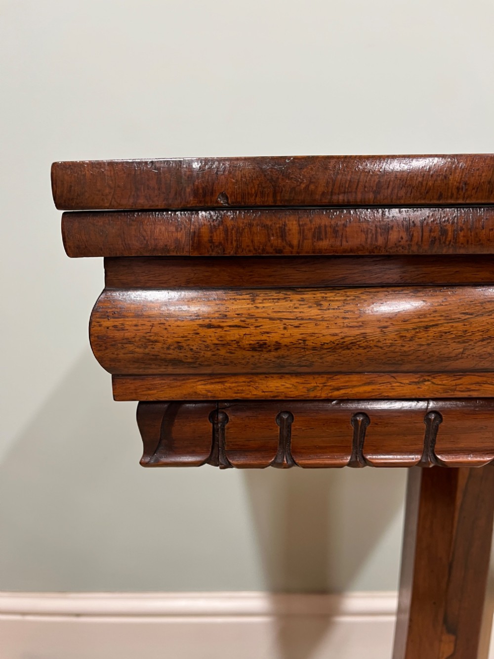 A 19th-century rosewood games table with a polished rectangular fold-over top, a faceted pedestal column, and a quadform base on flattened bun feet. View III