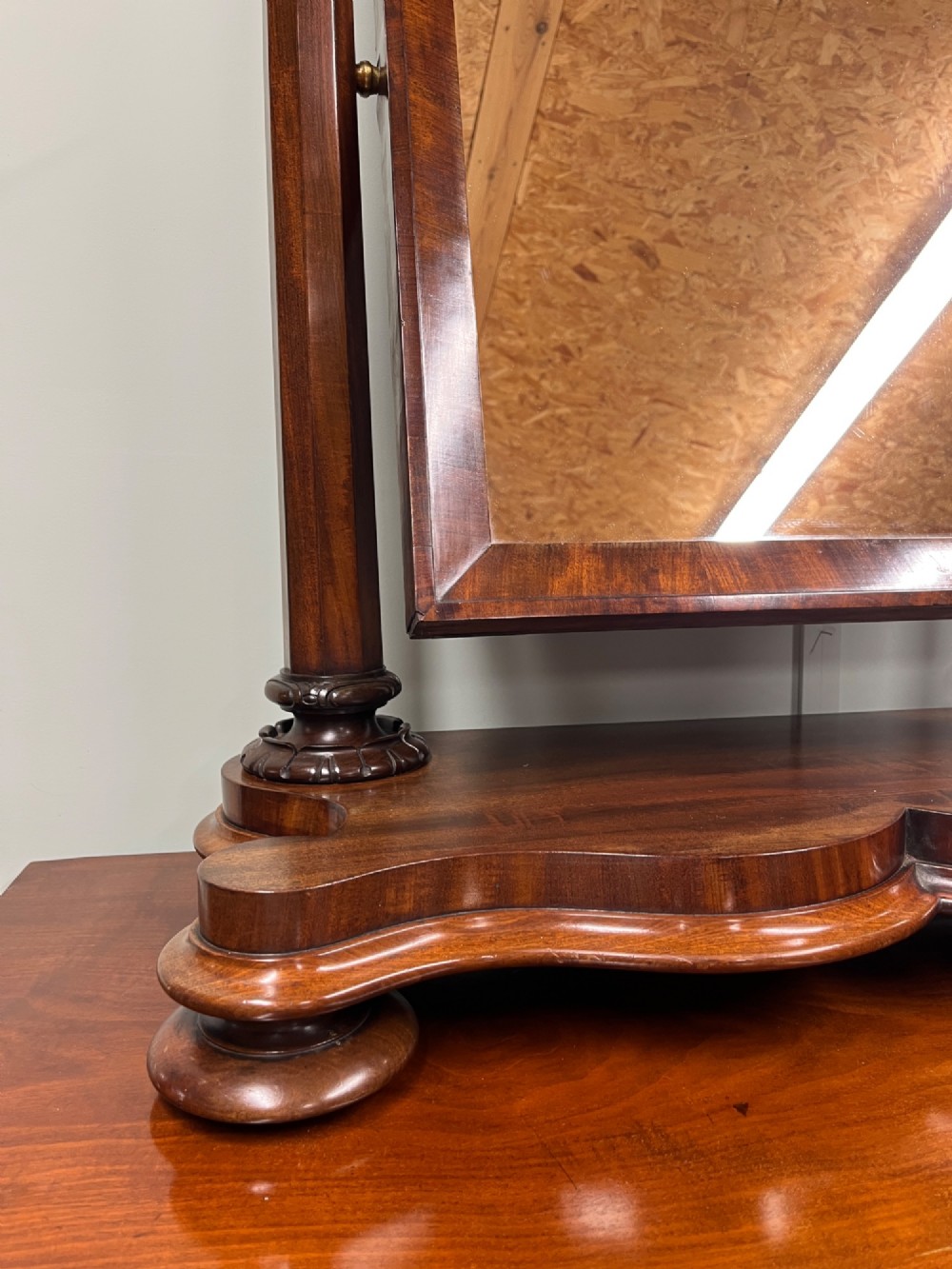 A 19th-century mahogany swing toilet mirror featuring carved support columns, two attached brass candle sconces, and a serpentine plinth base. View II