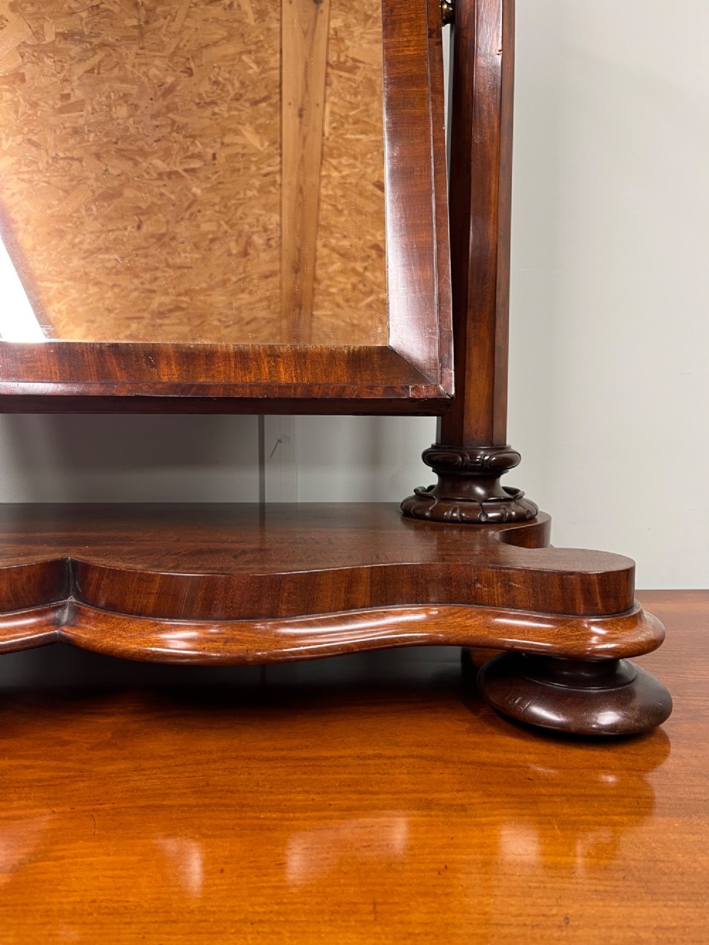 A 19th-century mahogany swing toilet mirror featuring carved support columns, two attached brass candle sconces, and a serpentine plinth base. View IV