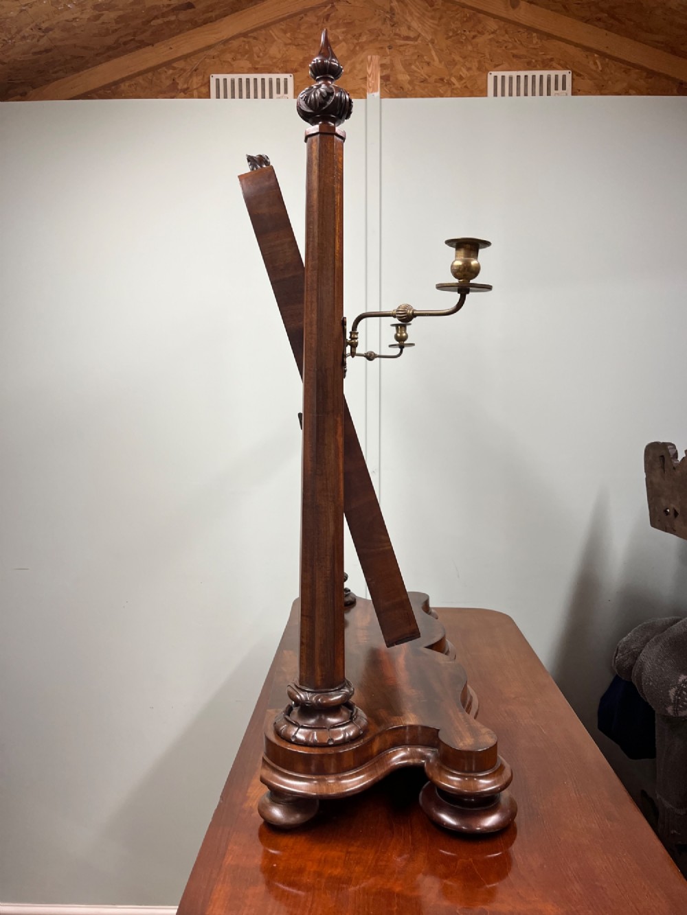 A 19th-century mahogany swing toilet mirror featuring carved support columns, two attached brass candle sconces, and a serpentine plinth base. View IX