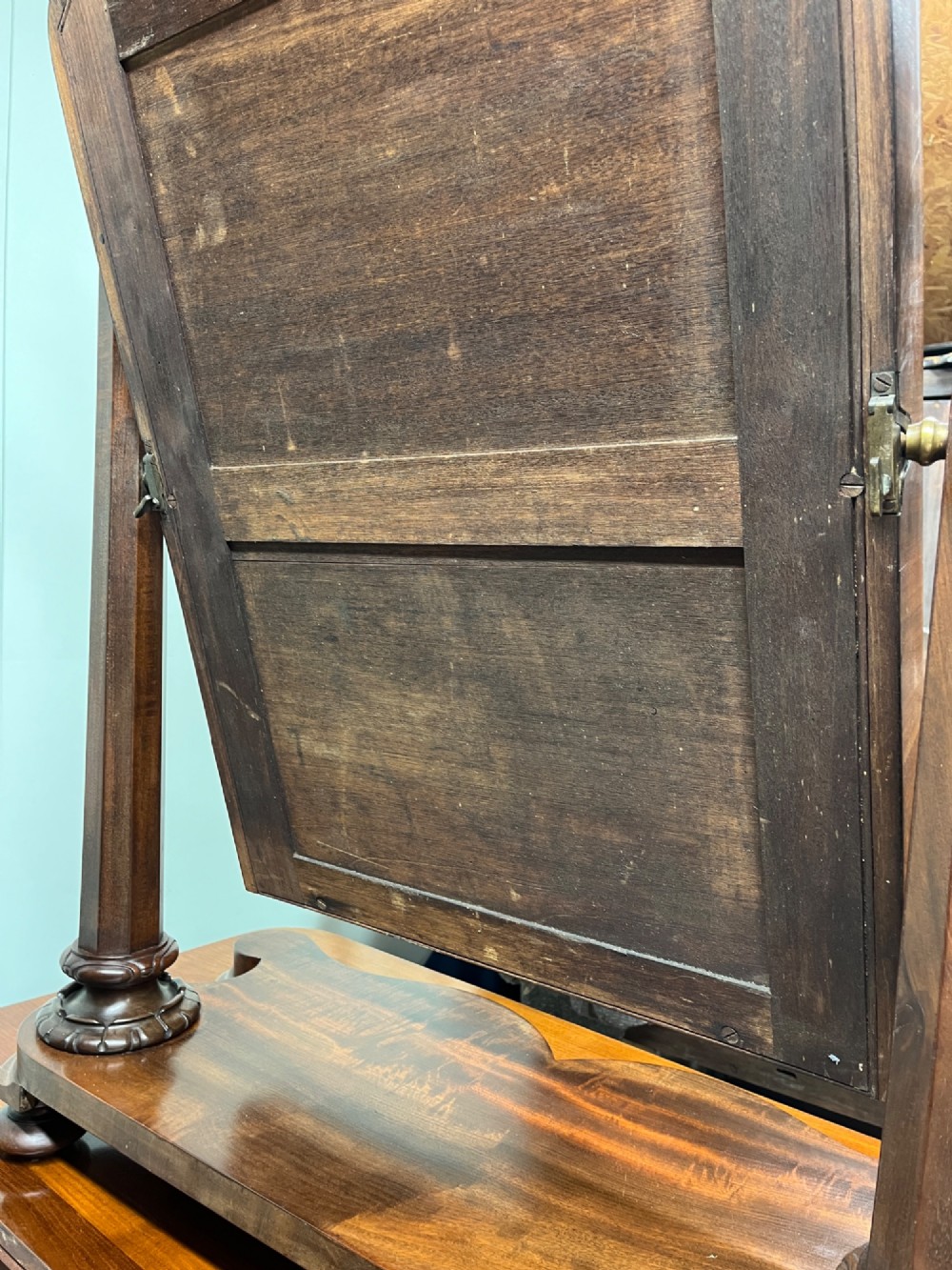 A 19th-century mahogany swing toilet mirror featuring carved support columns, two attached brass candle sconces, and a serpentine plinth base. View X