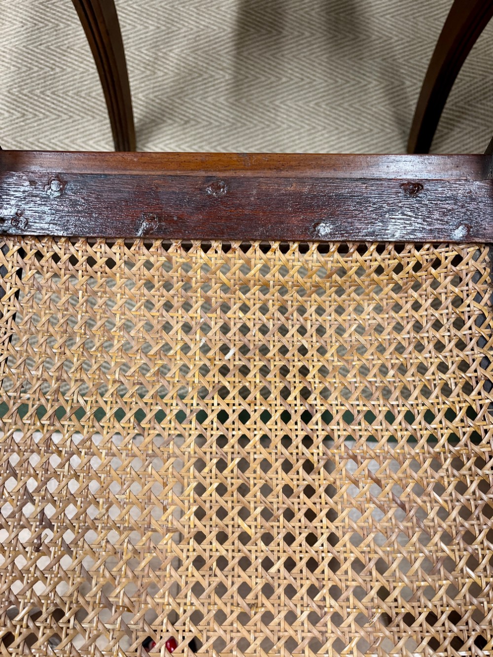 A set of six Regency carved rosewood dining chairs featuring carved anthemion back splats, sabre legs, and woven cane seats. View IV