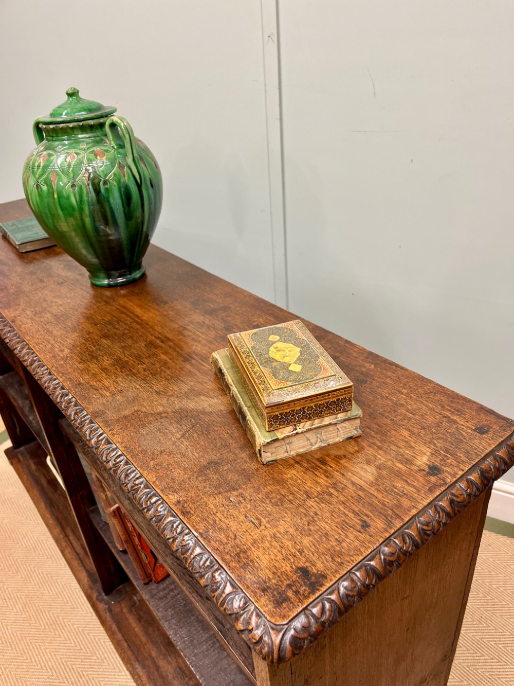 A low nineteenth-century open teak bookcase featuring two main sections with adjustable shelves and a carved egg-and-dart moulding along the top rim. View II