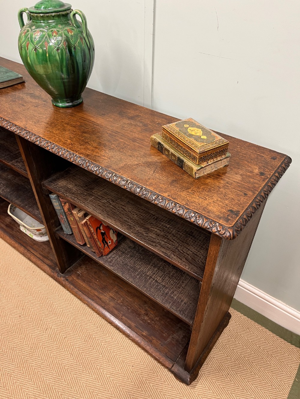A low nineteenth-century open teak bookcase featuring two main sections with adjustable shelves and a carved egg-and-dart moulding along the top rim. View IV