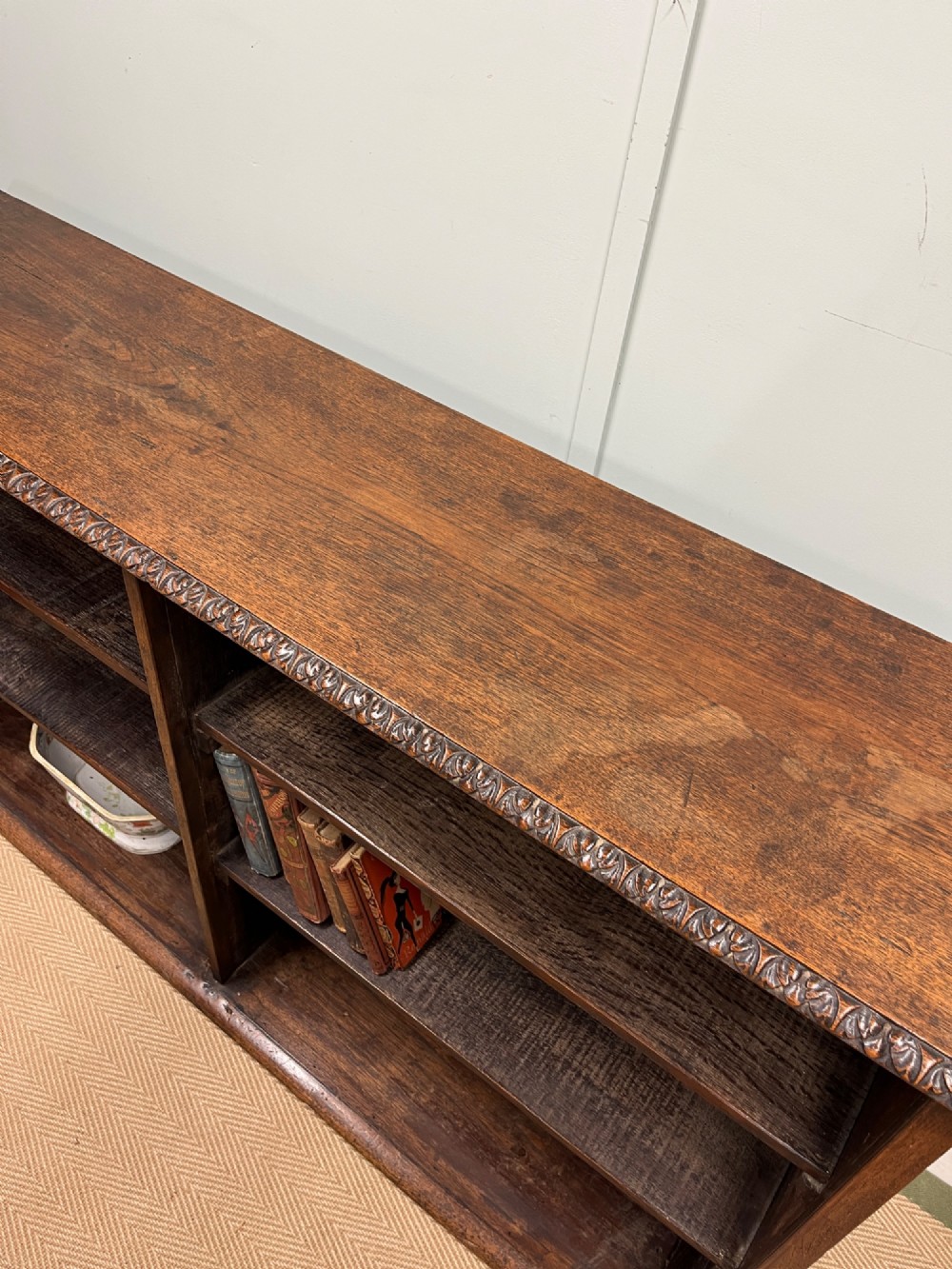 A low nineteenth-century open teak bookcase featuring two main sections with adjustable shelves and a carved egg-and-dart moulding along the top rim. View VII
