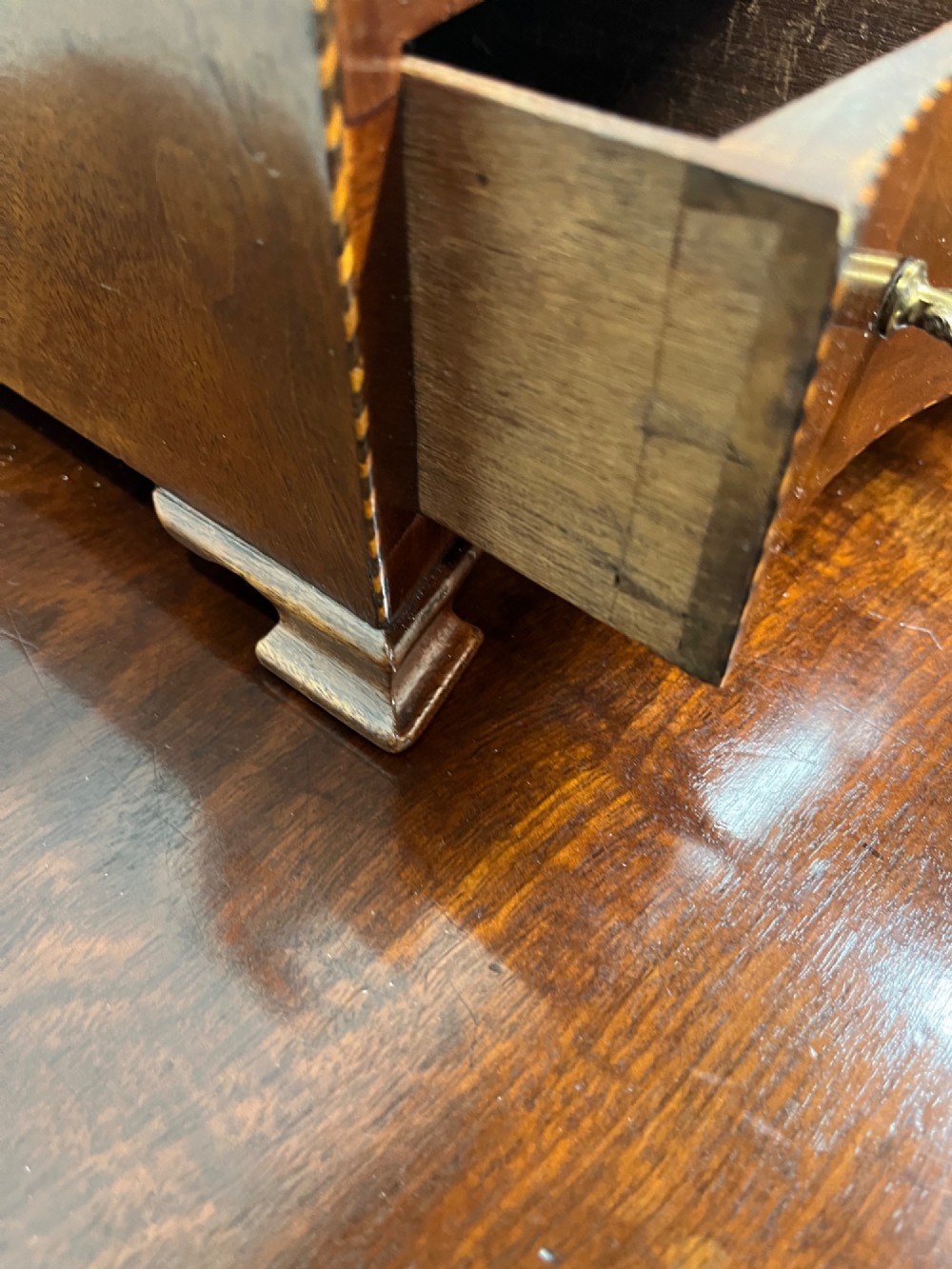 An antique Georgian mahogany toilet mirror featuring an oval adjustable glass frame mounted on curved supports above a three-drawer box base. View V