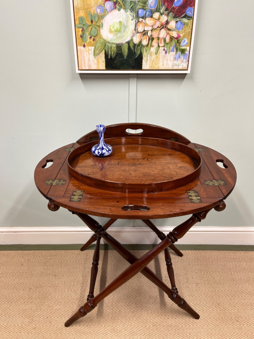 A 19th-century mahogany butlers tray with drop-down hinged sides and cutout hand-holes, set upon a turned folding X-frame stand. View III