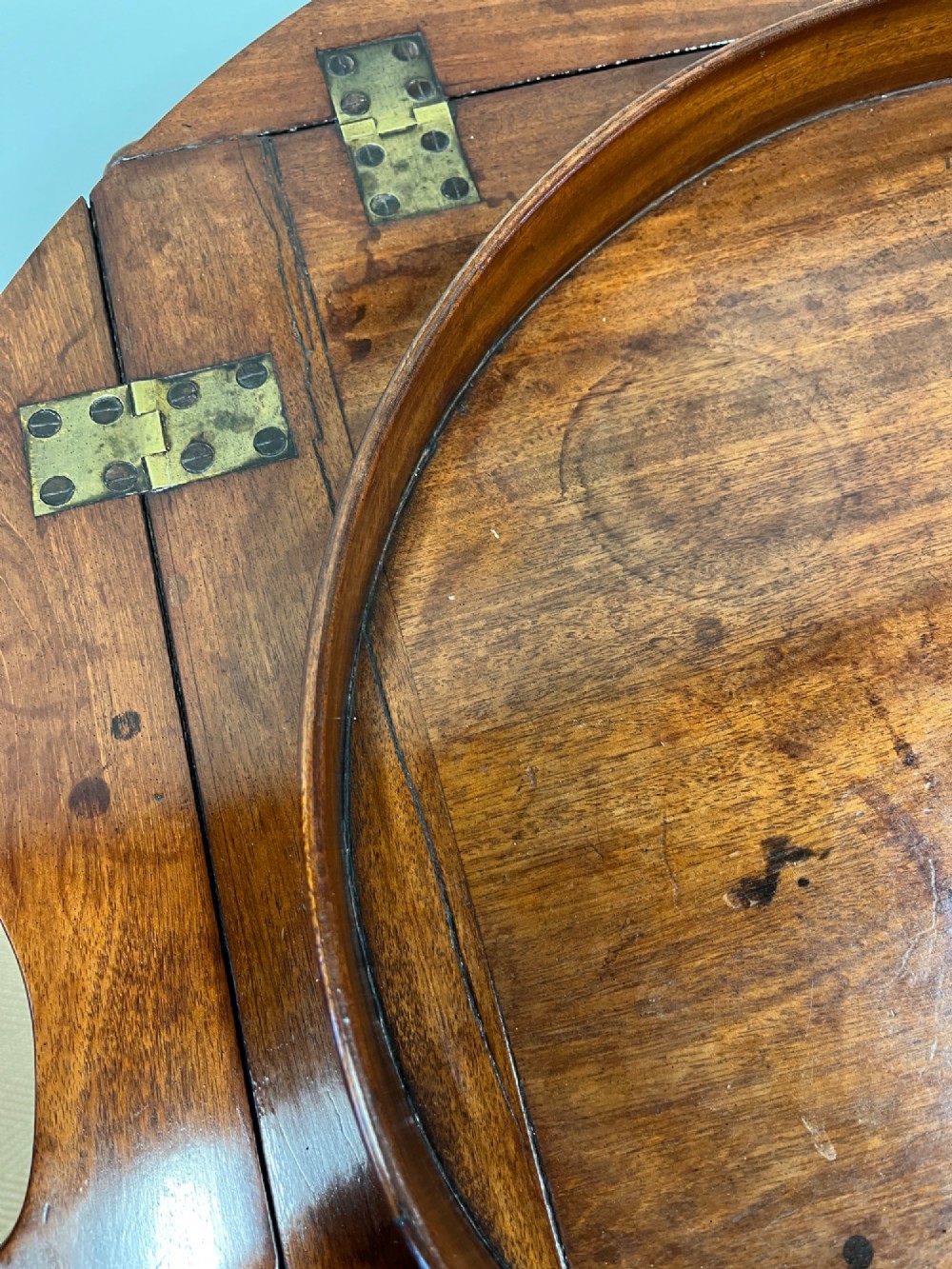 A 19th-century mahogany butlers tray with drop-down hinged sides and cutout hand-holes, set upon a turned folding X-frame stand. View VI