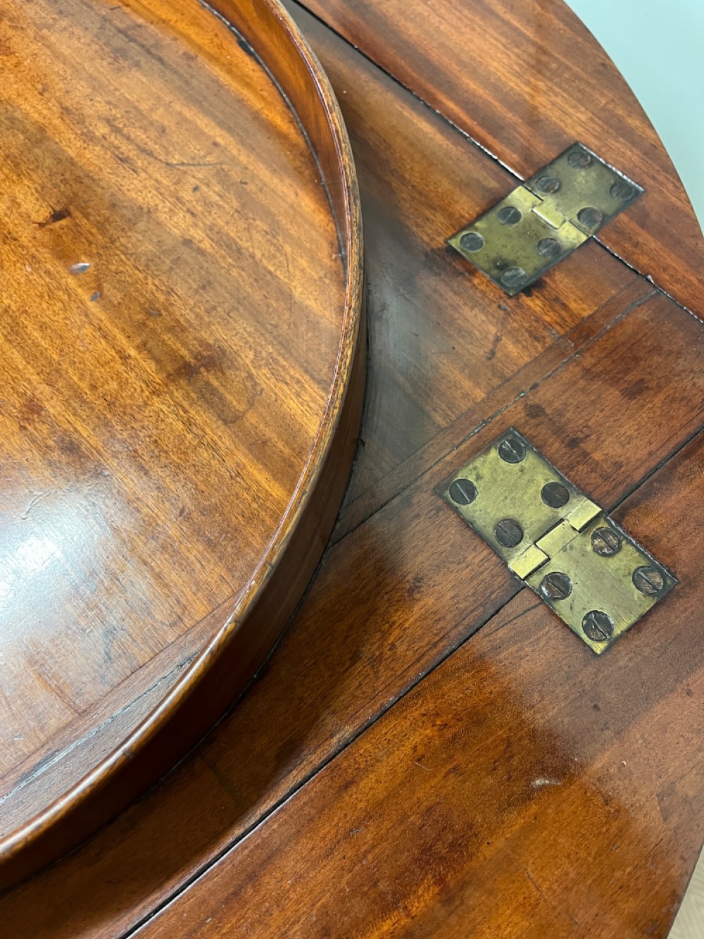 A 19th-century mahogany butlers tray with drop-down hinged sides and cutout hand-holes, set upon a turned folding X-frame stand. View VII