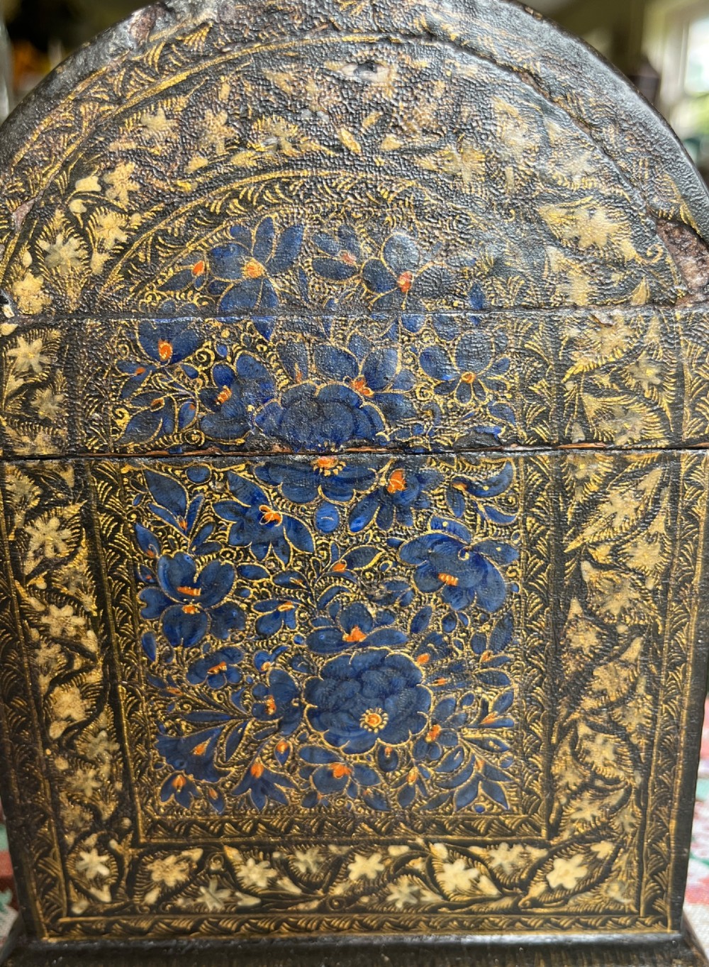 A 19th-century Kashmiri domed papier-mache box featuring detailed blue and gold floral hand-painted motifs with a decorative cream border. View V