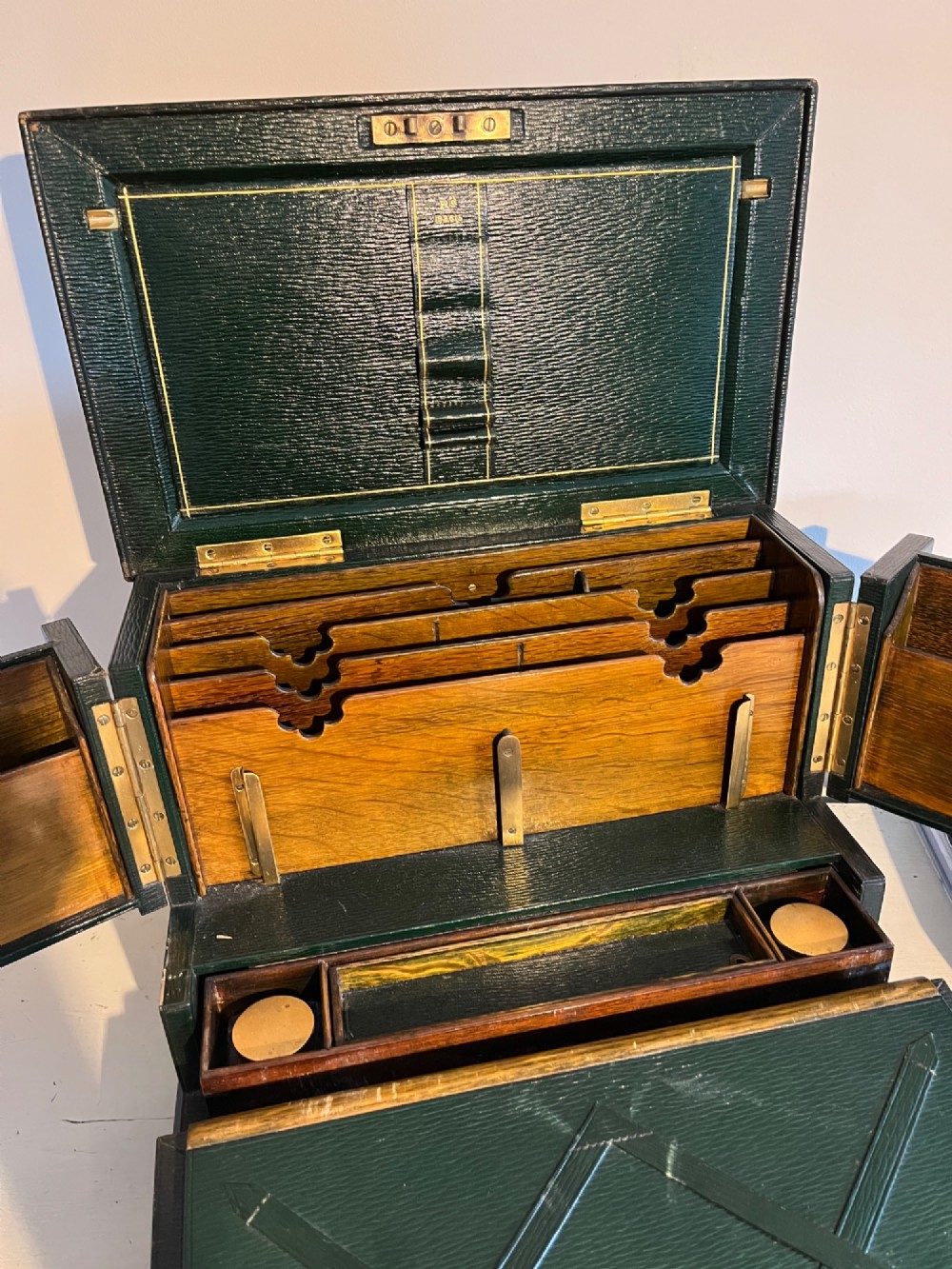 An open nineteenth-century dark green leather stationery box featuring brass fittings, interior memo panels, and compartmentalised sections. View III