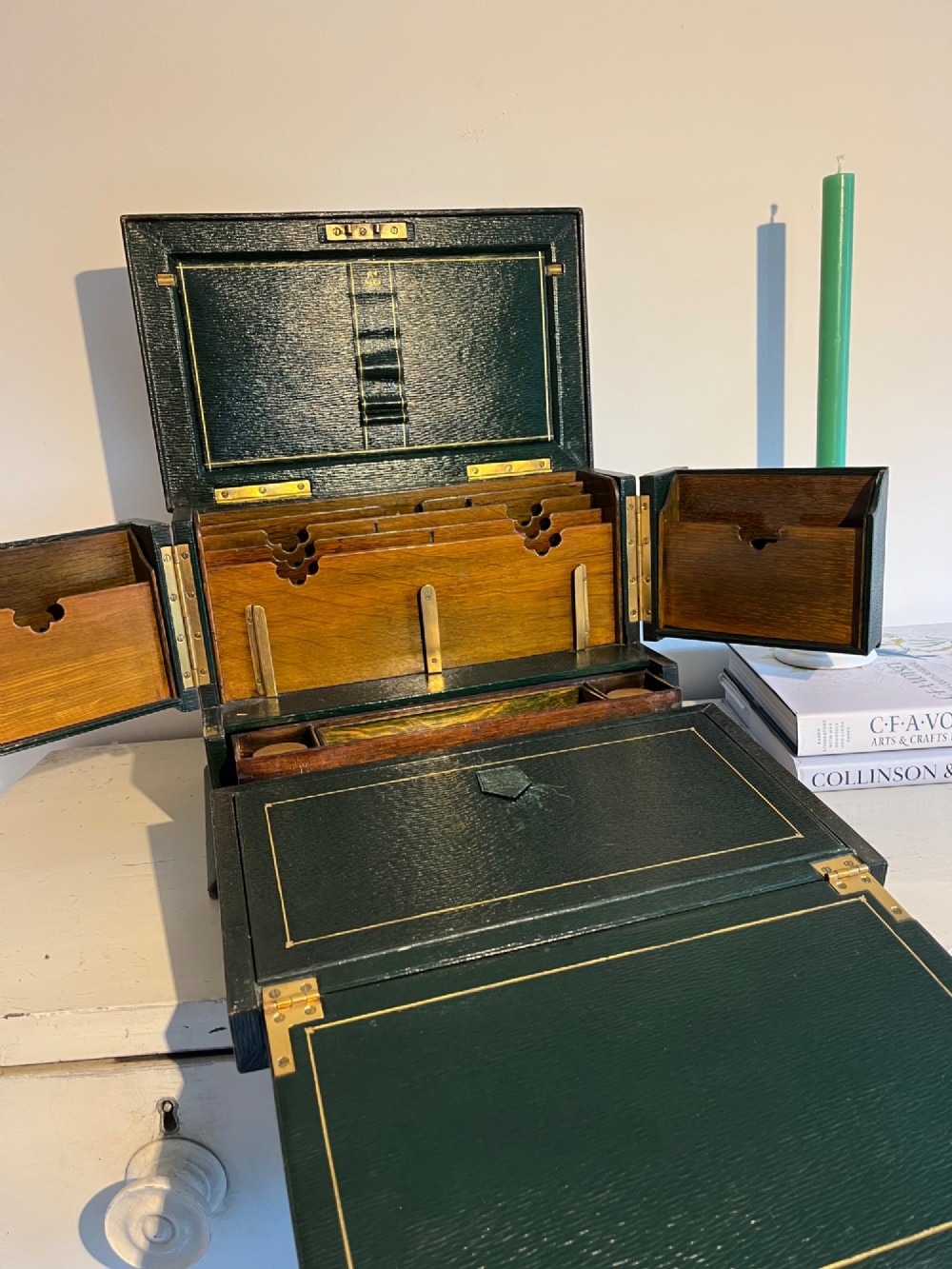 An open nineteenth-century dark green leather stationery box featuring brass fittings, interior memo panels, and compartmentalised sections. View V