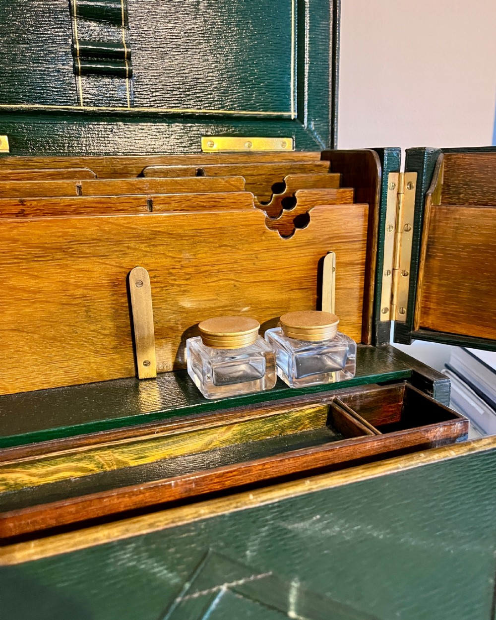 An open nineteenth-century dark green leather stationery box featuring brass fittings, interior memo panels, and compartmentalised sections. View VIII