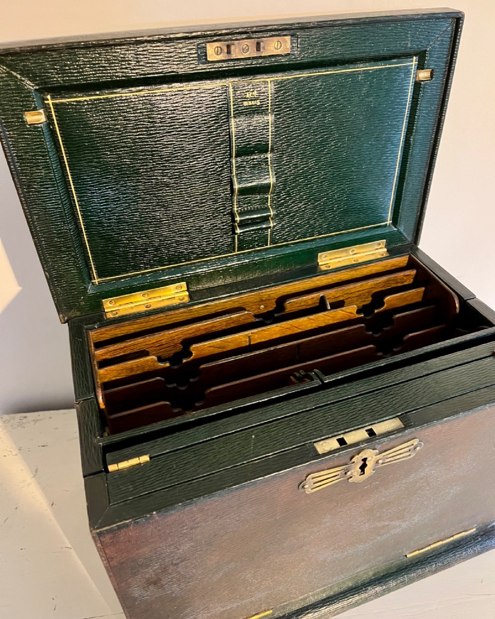 An open nineteenth-century dark green leather stationery box featuring brass fittings, interior memo panels, and compartmentalised sections. View X