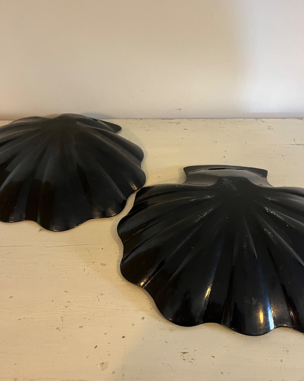 A pair of black lacquered shell-shaped trays decorated with a gold star pattern, fluted edges, and integrated cut-out handles. View III