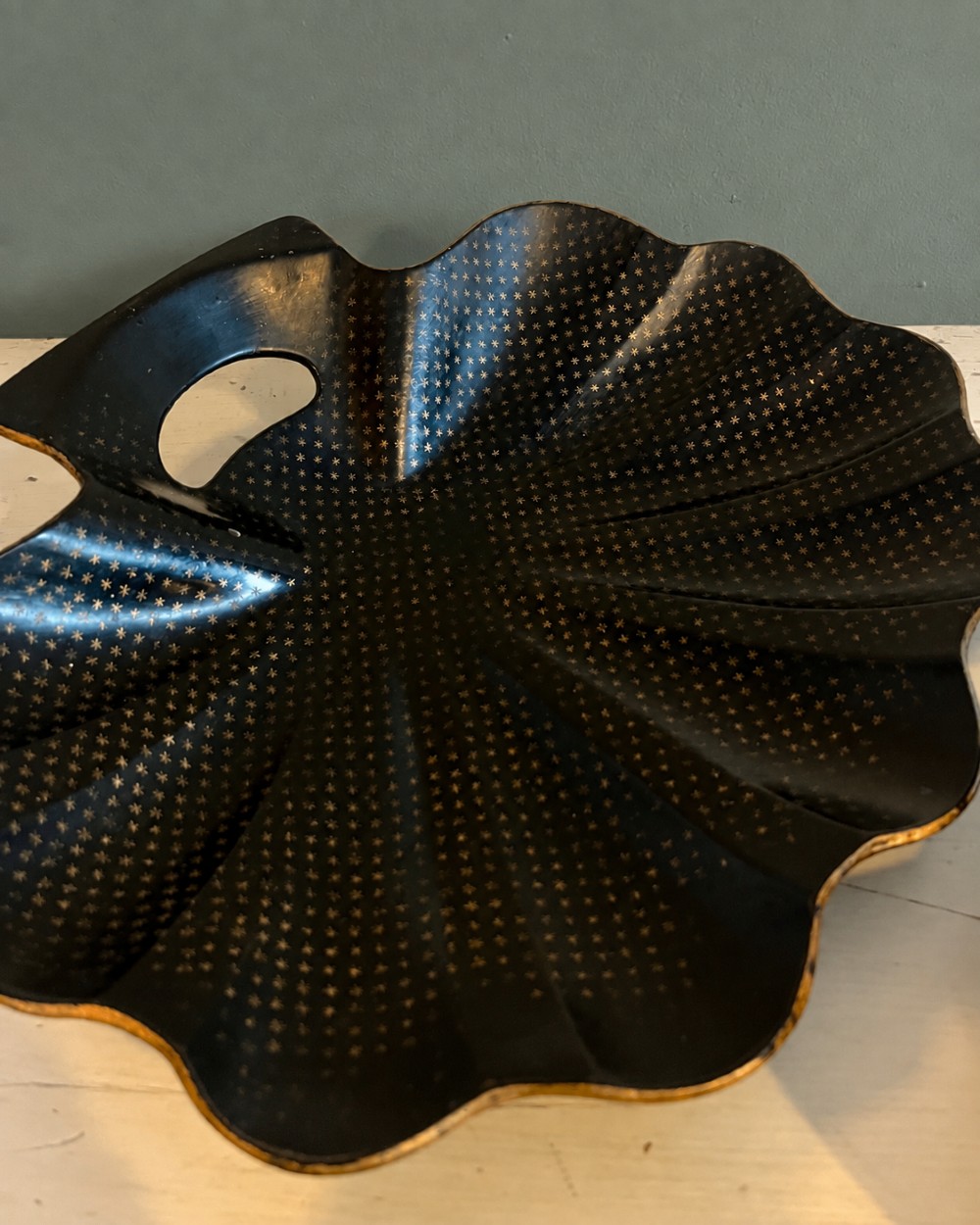 A pair of black lacquered shell-shaped trays decorated with a gold star pattern, fluted edges, and integrated cut-out handles. View V